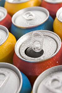 Close Up Of Multi Colored Soda Cans With One Open