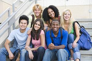 Six people sitting on staircase outdoors smiling