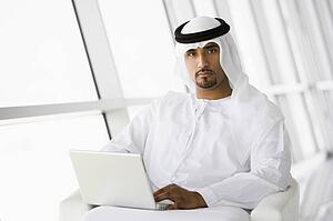 Man indoors with laptop (high key/selective focus)