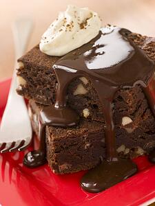 Chocolate Brownies On A Plate With Chocolate Fudge Sauce And Cream