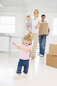 Family with box moving into new home smiling