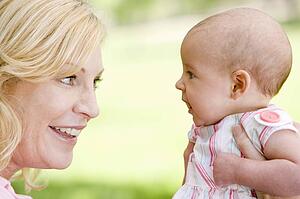 Mother and baby outdoors smiling