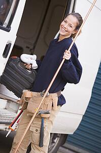 Plumber standing with van smiling