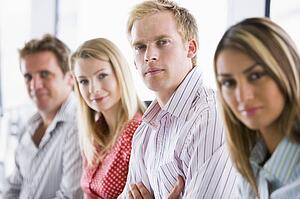 Four businesspeople sitting indoors smiling