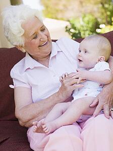 Grandmother outdoors on patio with baby smiling