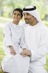 Man and young boy outdoors in a park smiling (selective focus)