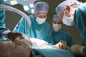 Three Surgeons Operating On A Patient