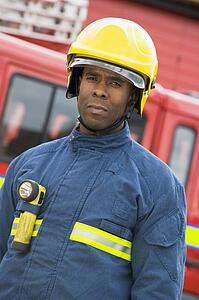 Fireman standing by fire engine wearing helmet