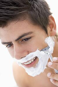 Man shaving and smiling