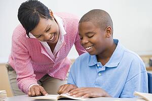 Student in class reading with teacher