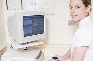 Dental assistant using computer smiling