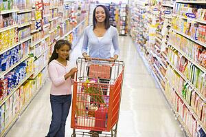 Mother and young daughter shopping at a grocery store