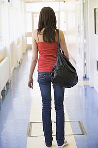 Student standing in corridor (high key)