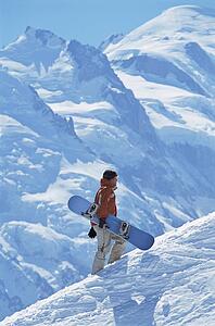 Snowboarder going up hill carrying board