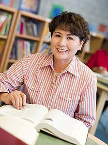 Woman sitting in library with a book (selective focus)