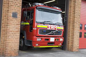 Firefighters driving fire engine out of the firehouse