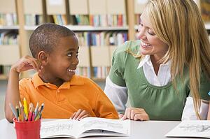 Student in class reading with teacher