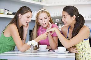 Young woman showing off engagement ring to friends