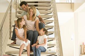 Family sitting on staircase smiling