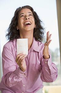 Woman with winning lottery ticket excited and smiling