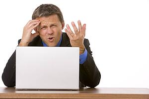 Businessman Frowning While Looking At Laptop 
