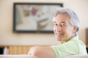 Man watching television smiling
