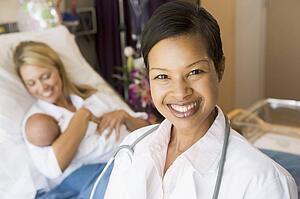 Doctor Standing In Her Patients Room, Woman Holding Baby