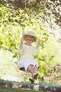 Woman on a swing outdoors smiling