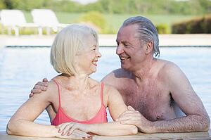 Couple in outdoor pool smiling