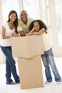 Family with boxes in new home smiling