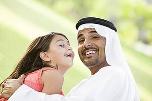 Man and young girl outdoors in park playing and smiling (selective focus)
