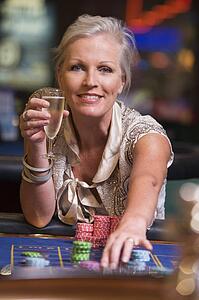 Woman in casino playing roulette and smiling (selective focus)