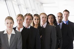 Group of co-workers standing in office space smiling (high key/depth of field)
