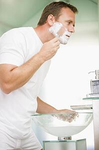 Man in bathroom shaving