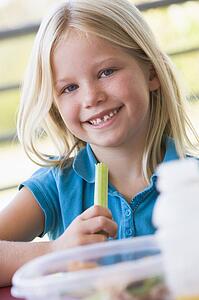 Student outdoors eating lunch (selective focus)