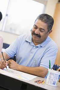Adult student in class taking notes