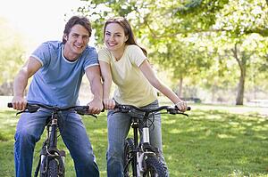 Couple on bikes outdoors smiling
