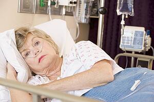 Senior Woman Lying In Hospital Bed