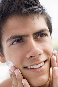 Man applying shaving cream smiling