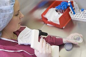 Embryologist adding sperm to egg