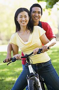 Couple on a bike outdoors smiling