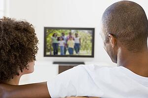 Couple in living room watching television