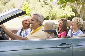 Family in convertible car smiling
