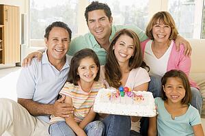Family in living room with cake smiling