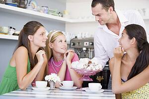 Man offering sweet treats to three young women