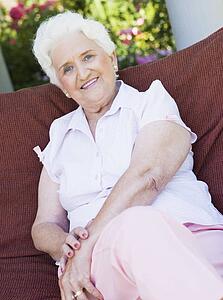 Senior woman sitting outdoors on a chair