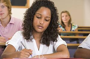 Student in class taking notes (selective focus)