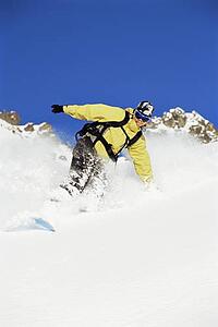 Snowboarder coming down hill smiling