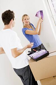 Couple with paint swatches in new home smiling