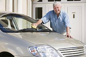 Senior man washing his car outside his home